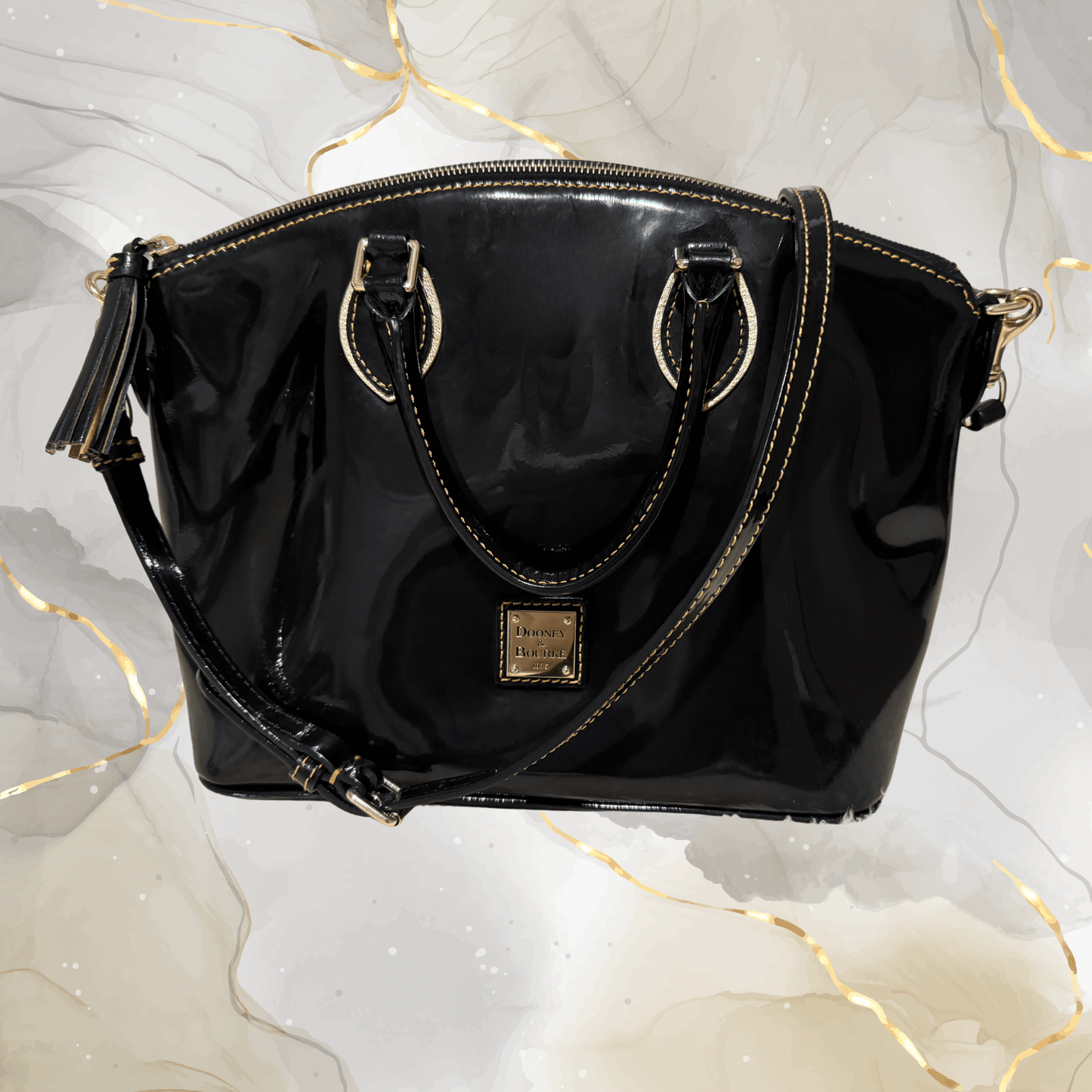 Pre-owned Dooney & Bourke black patent leather tassel satchel bag with gold-tone hardware.